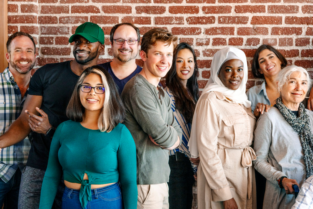 group of happy diverse people smiling while standing in front of a brick wall